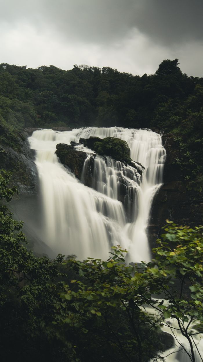 Waterfall cascading through a rocky valley in Coorg forest
