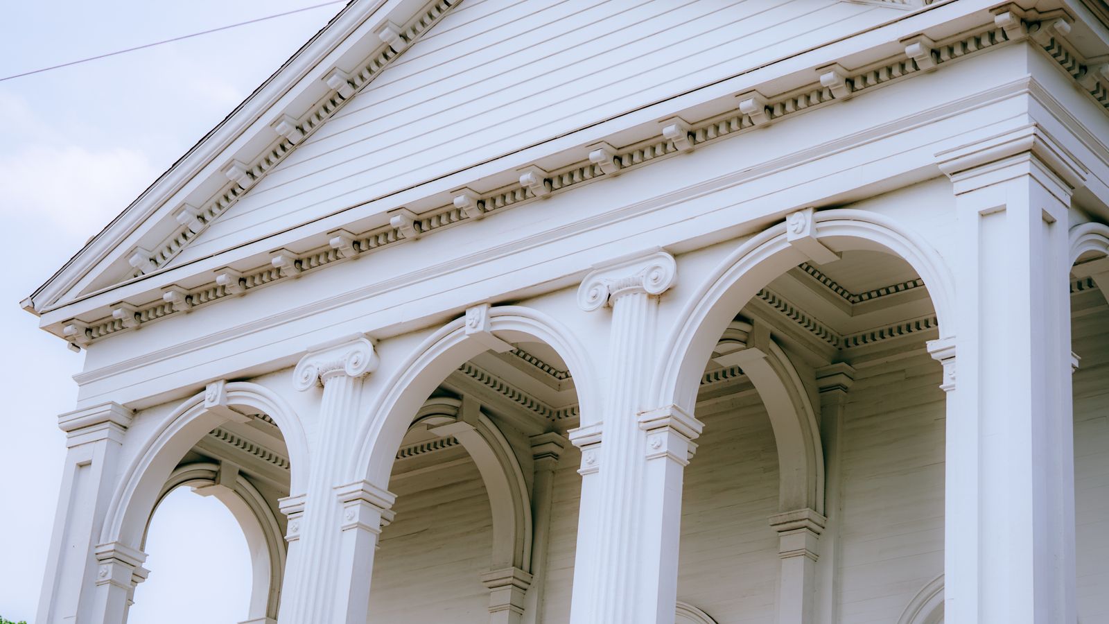 A close-up view of a neoclassical building facade featuring detailed arches and columns.