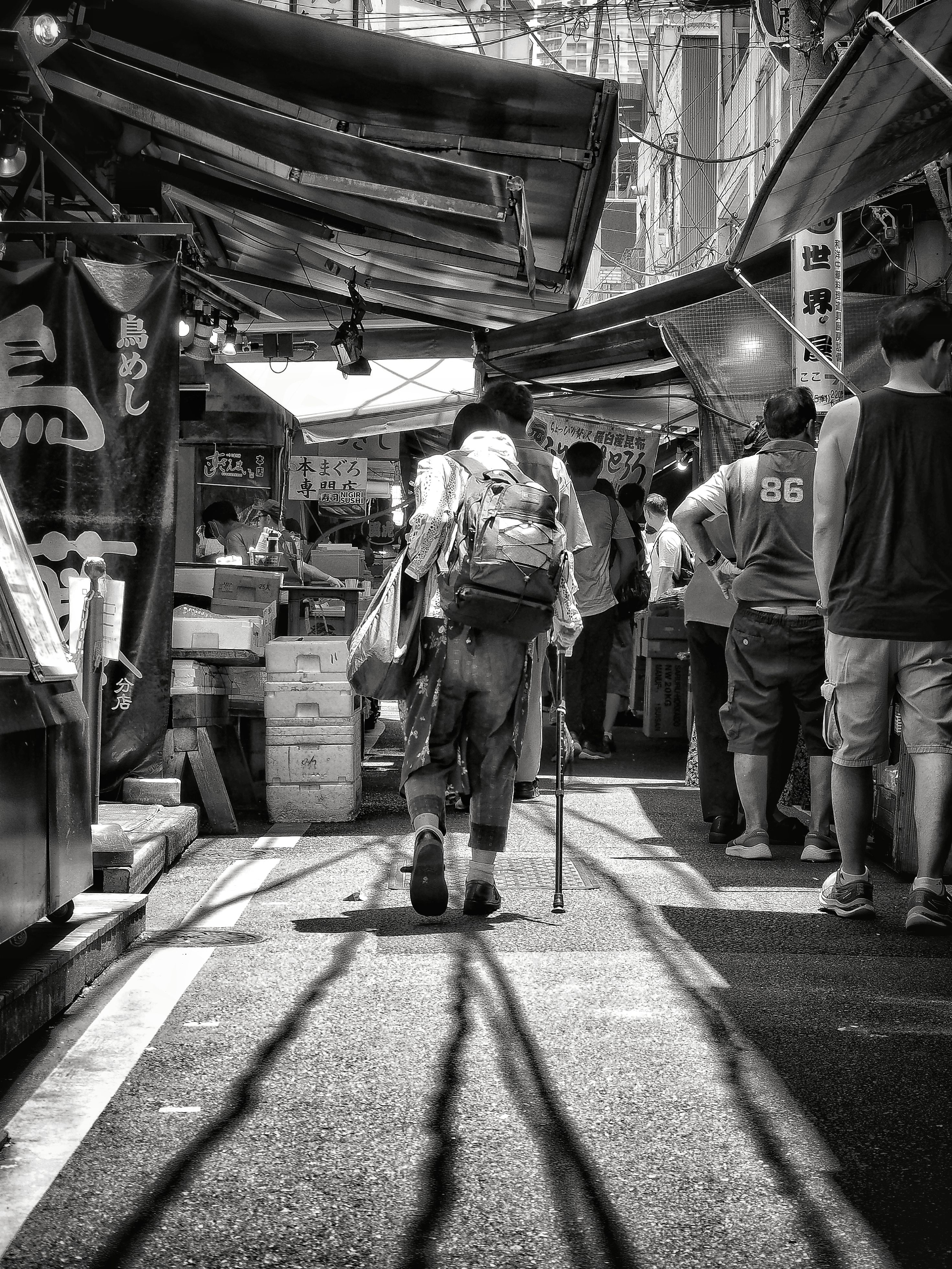 Man with Backpack on Street Market in Black and White · Free Stock Photo