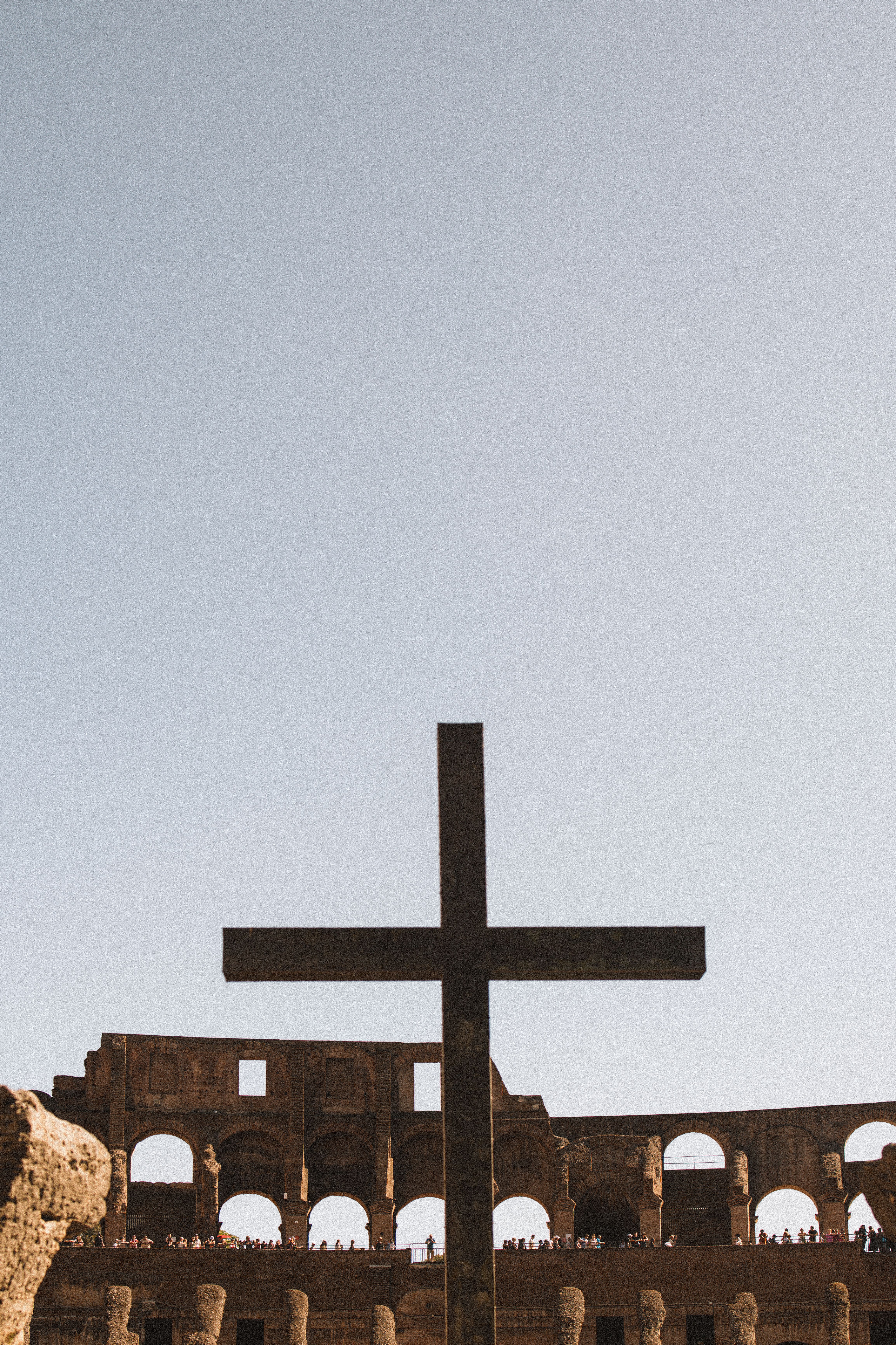 A cross in front of an old roman building · Free Stock Photo
