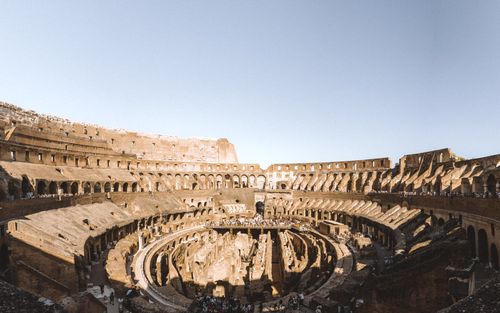 Free Explore the historic interior of the Colosseum in Rome, Italy, under a clear sky. Stock Photo