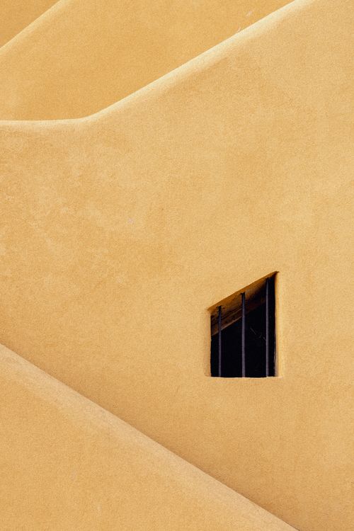 Free Close-up of a yellow wall with a small window, showcasing minimalist architecture. Stock Photo