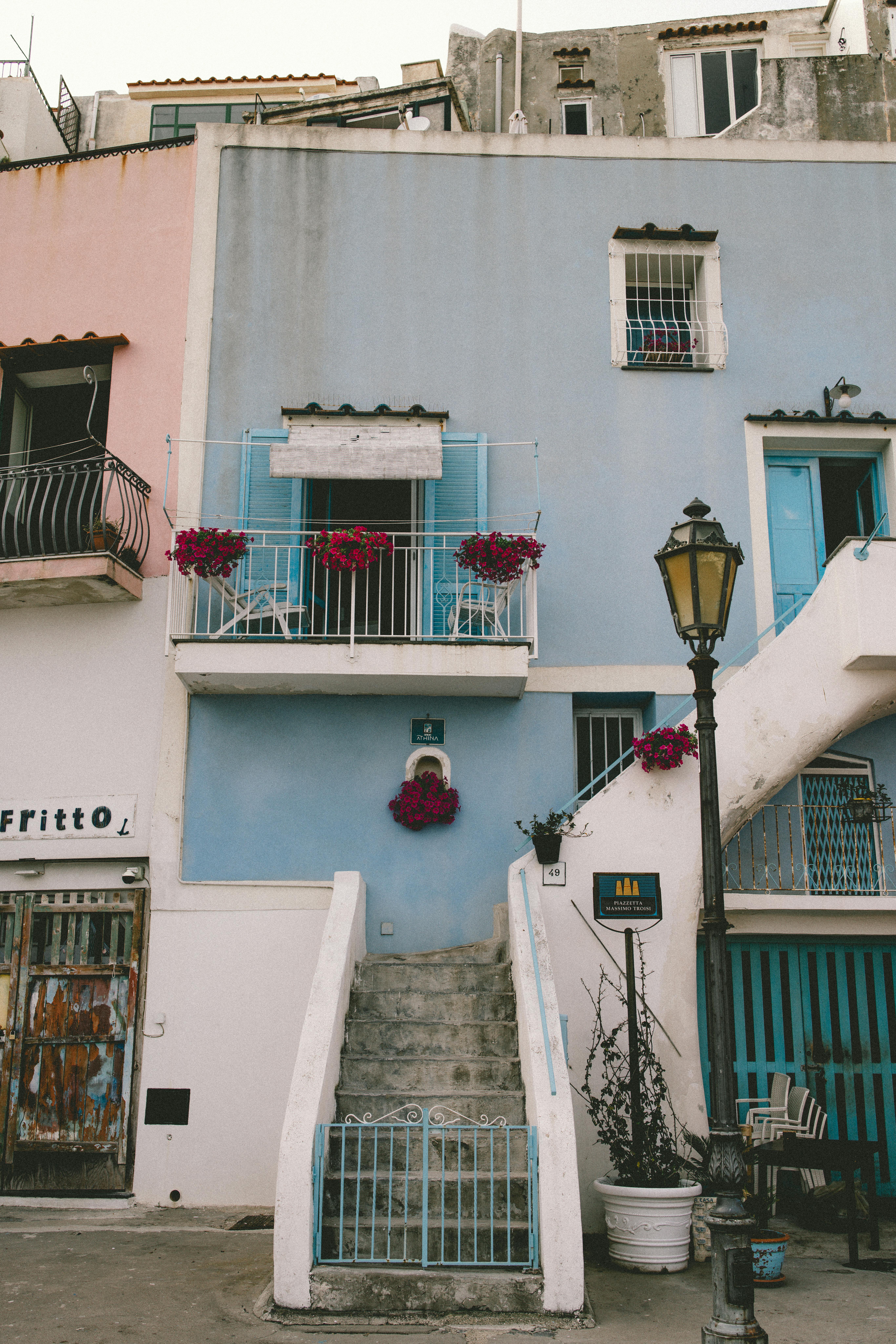 Explore the quaint charm of a pastel-colored townhouse facade in Procida, Italy.