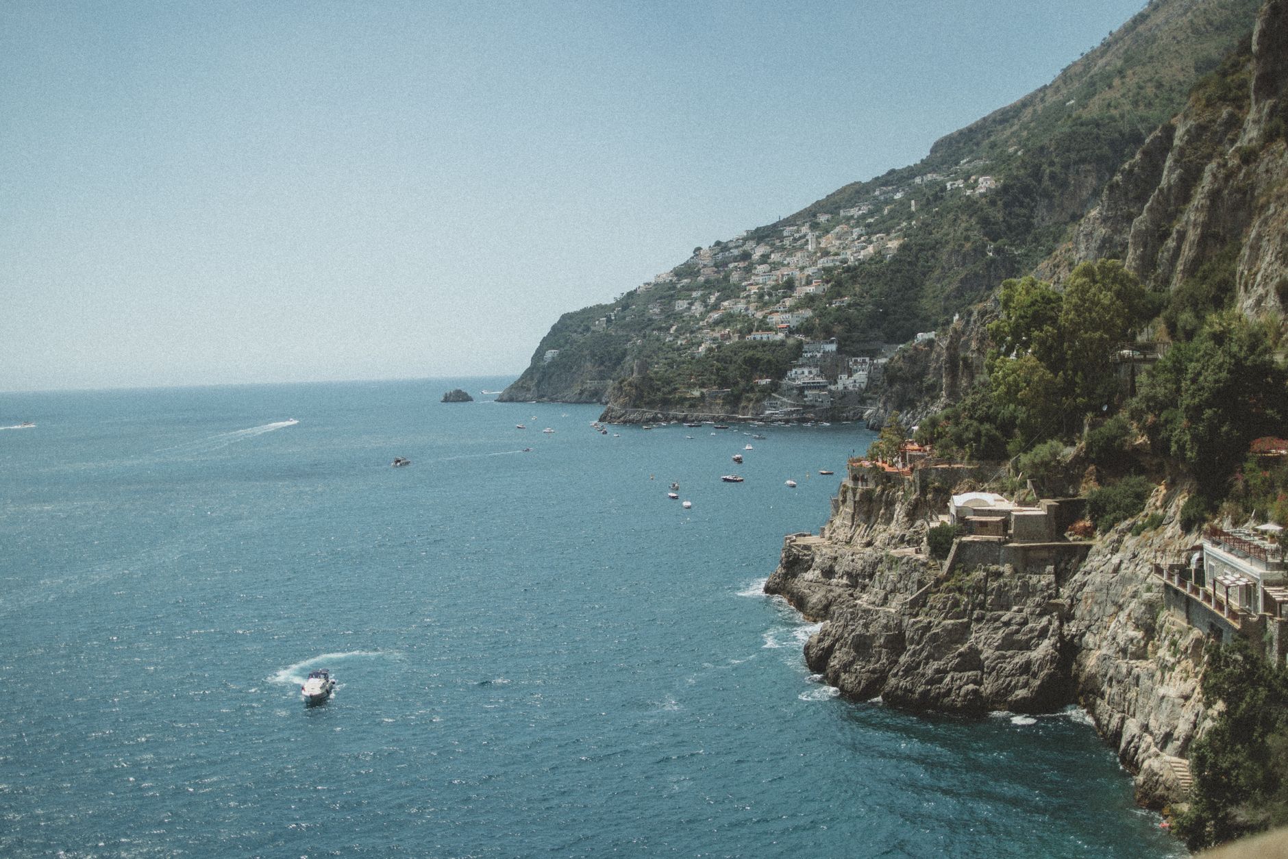 Stunning aerial view of Furore, Italy, showcasing the coastline and Tyrrhenian Sea under a clear blue sky.