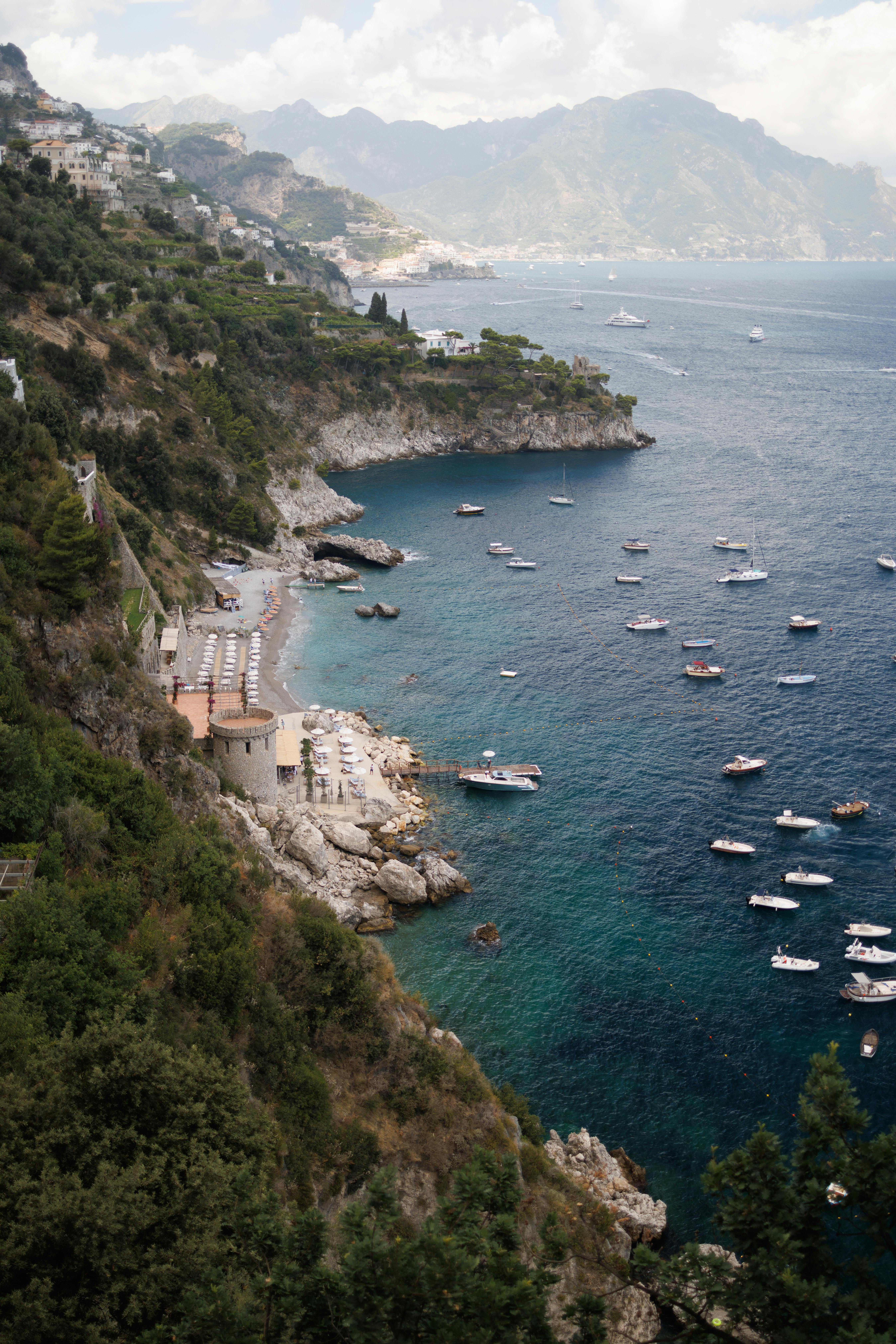 A beautiful coastal vista with numerous boats on the calm, blue Mediterranean Sea.