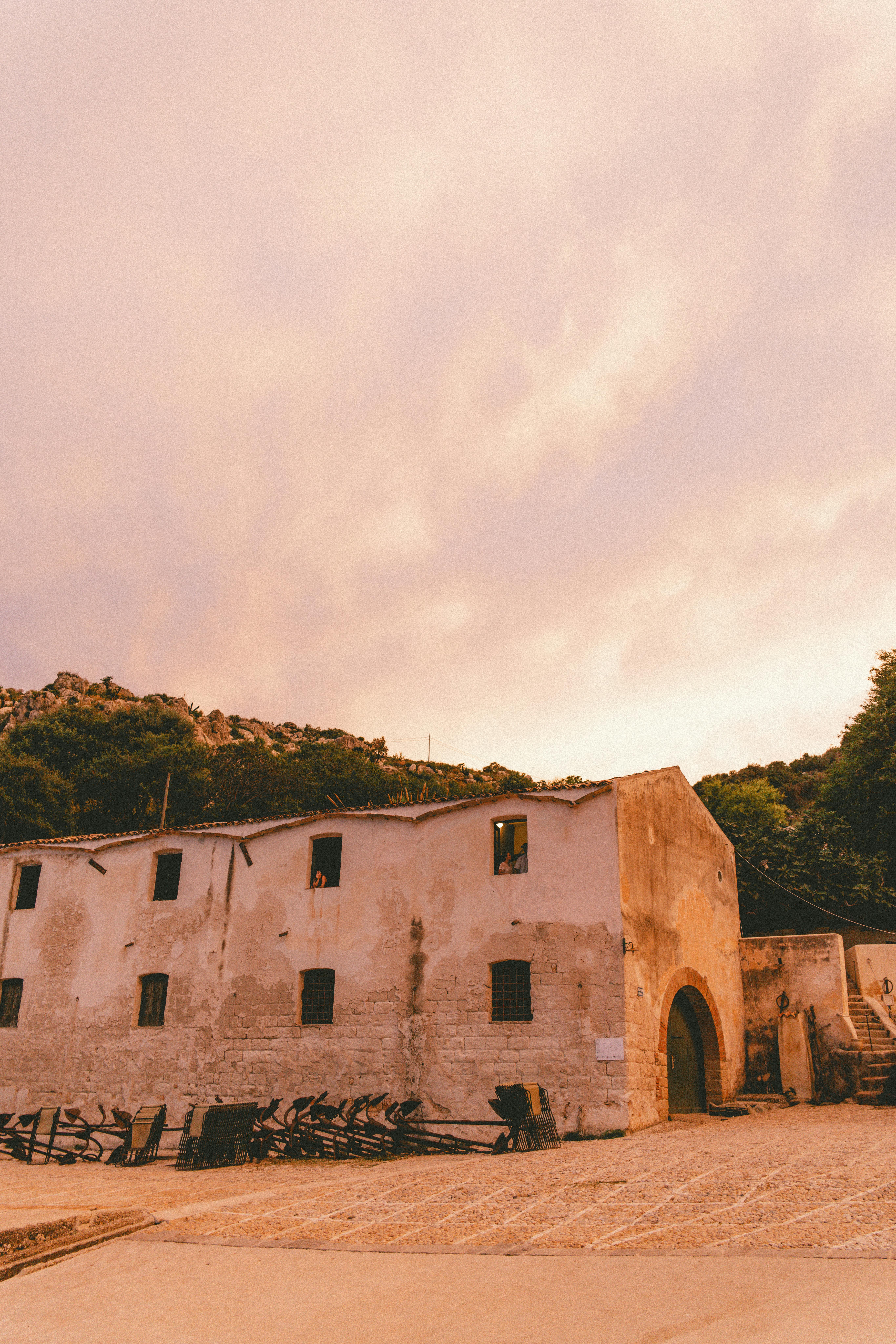 Ancient stone building with rustic charm under a warm sunset sky.