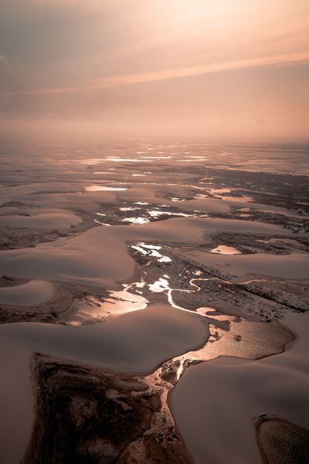 Stunning aerial panorama of frozen lakes and dunes at dusk in Atins, Brazil.