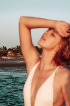 A blurred portrait of a woman posing gracefully by the beach in Atins, Brazil at sunset.