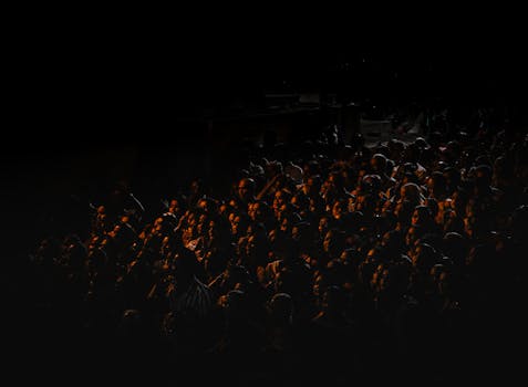 A captivating image capturing a large crowd gathered in darkness, illuminated by warm light, evoking a festival atmosphere in India.