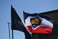 Vibrant Utah state and beehive flags waving in the wind, symbolizing state pride and heritage.