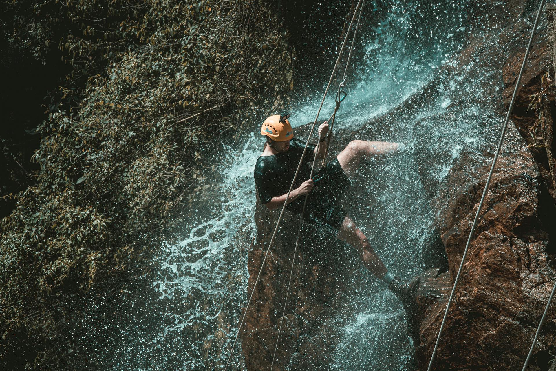 Active Man Rappelling on Cliff