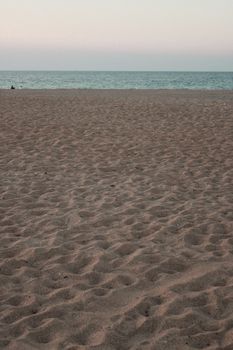 Peaceful beachscape featuring sandy shore and calm sea under a soft sky.