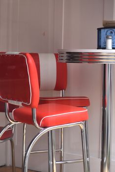 Red and chrome diner chairs and table capturing classic retro style in an indoor setting.
