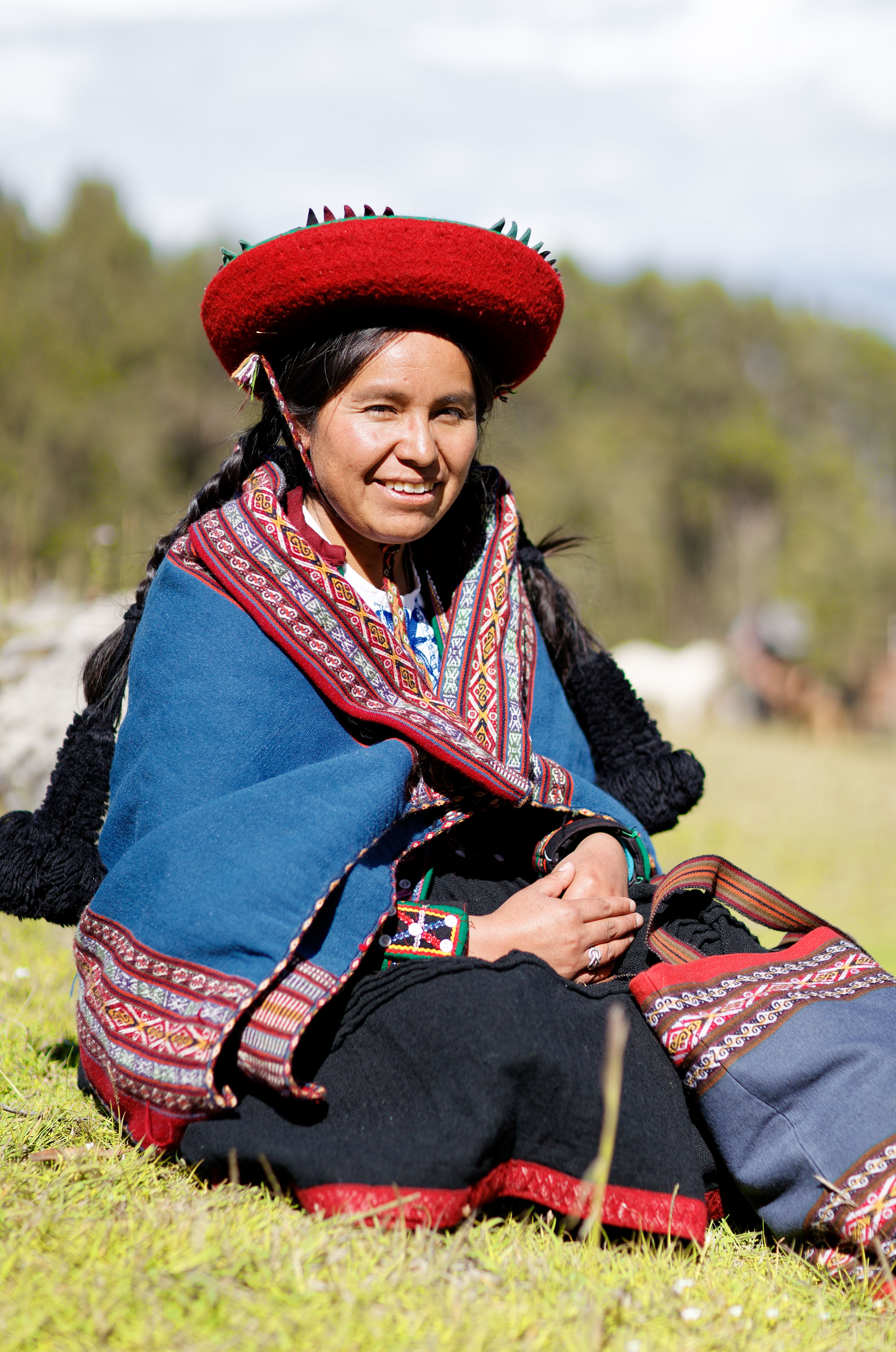 Smiling Quechua woman in traditional attire in the highlands of Cusco, Peru.