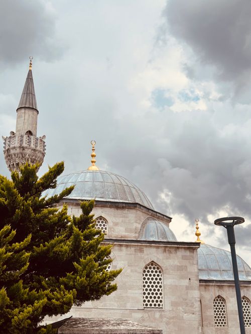 Free A stunning mosque with a dome against a cloudy, dramatic sky, highlighting religious architecture. Stock Photo