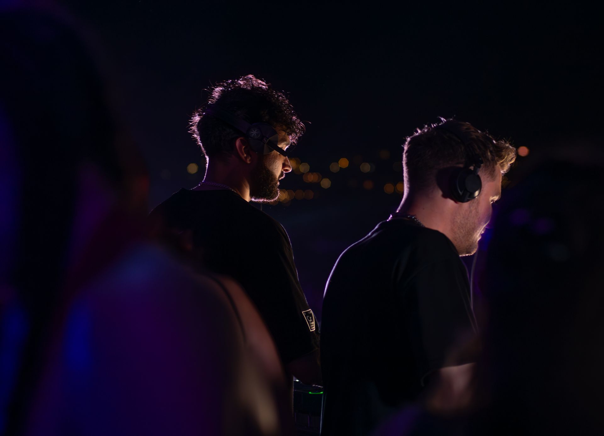 Two DJs wearing headphones performing at a nighttime event in Sozopol, Bulgaria.