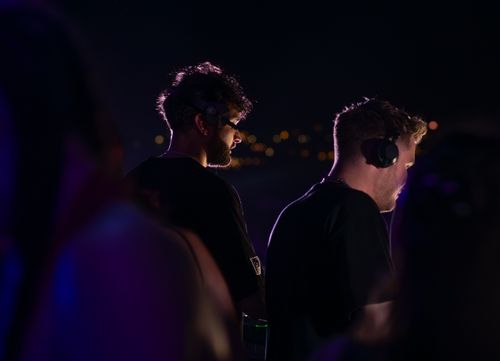 Free Two DJs wearing headphones performing at a nighttime event in Sozopol, Bulgaria. Stock Photo