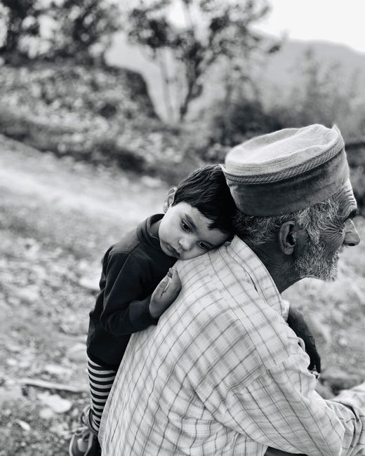 A touching black and white portrait of a child resting on a grandfather's shoulder in Shimla, India.
