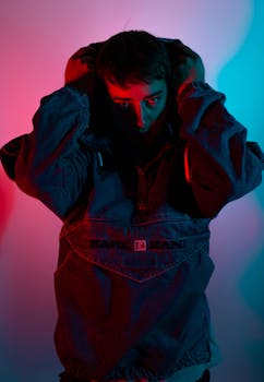 在蓝红灯光映照下，一名男子的肖像显得格外戏剧化，营造出阴郁的氛围