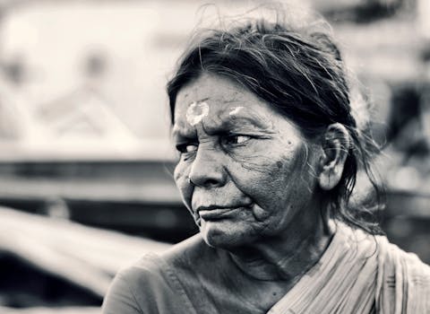 一幅捕捉情感的黑白肖像，描绘了一位沉思的印度年长妇女