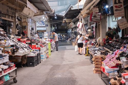 Free Vibrant street market in İzmir showcasing shoes and bags with shoppers exploring the stalls. Stock Photo