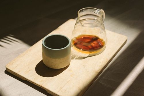 Free A transparent jug and an empty cup on a sunlit wooden tray, creating a warm, inviting setting. Stock Photo
