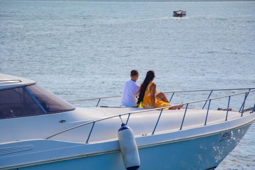 Man and woman enjoying a sunny day on a yacht, perfect vacation getaway.