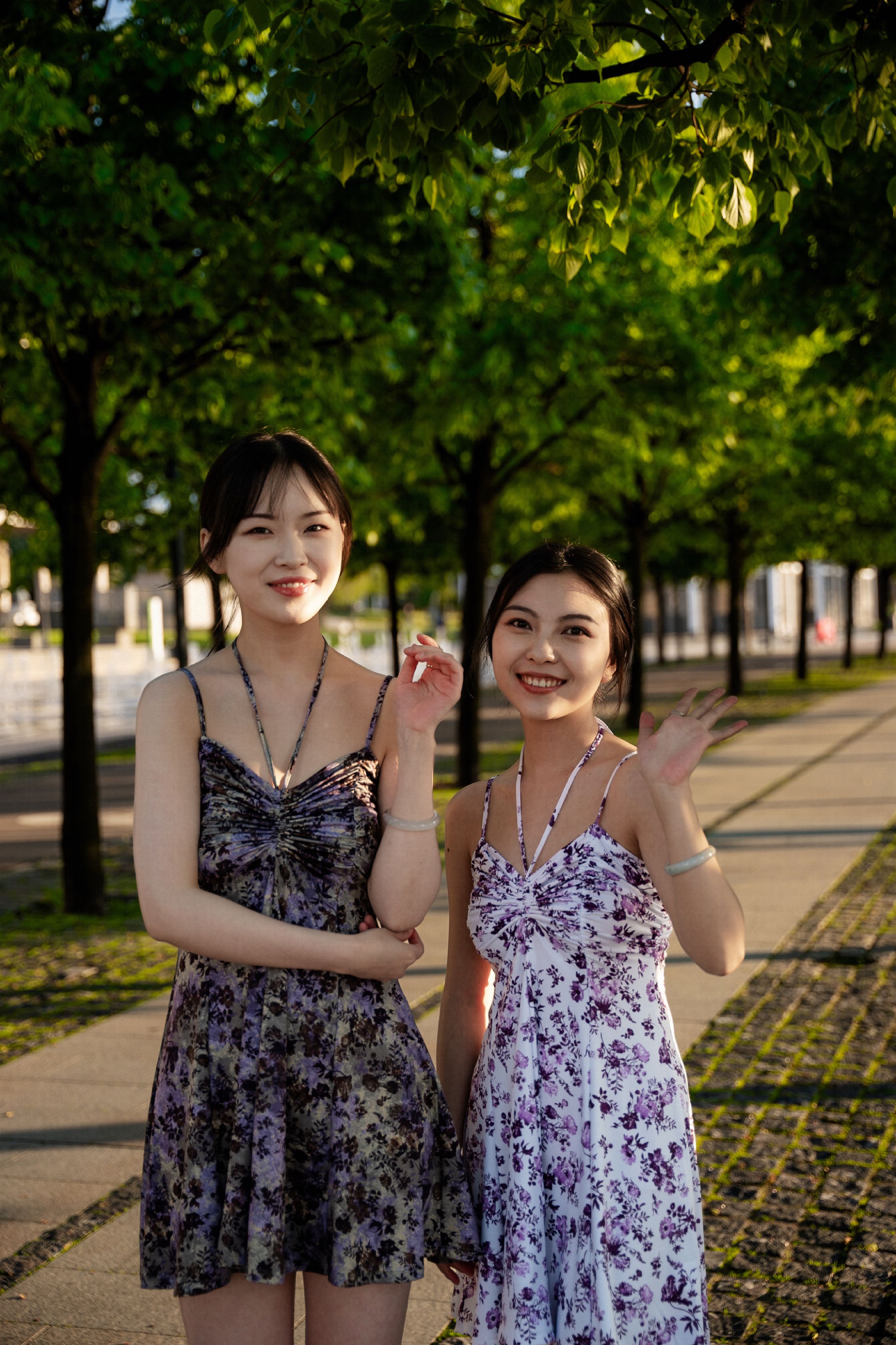 Two Women in Dresses Standing on the Sidewalk · Free Stock Photo