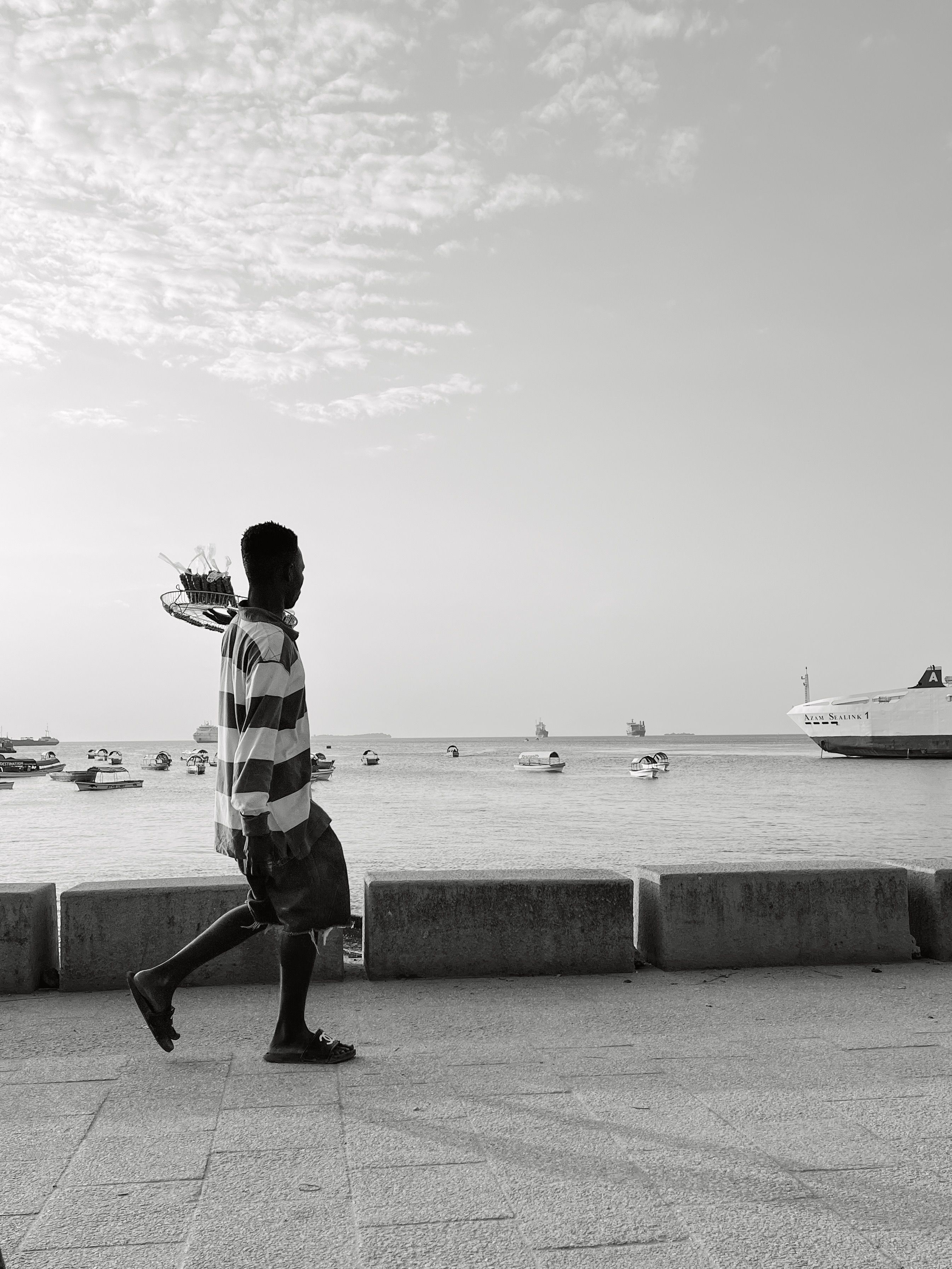 Black and White Photo of a Man Walking on the Shore · Free Stock Photo