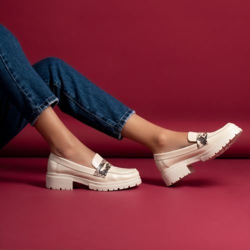 Free Close-up of women's legs in denim jeans wearing stylish moccasins on an elegant red background. Stock Photo