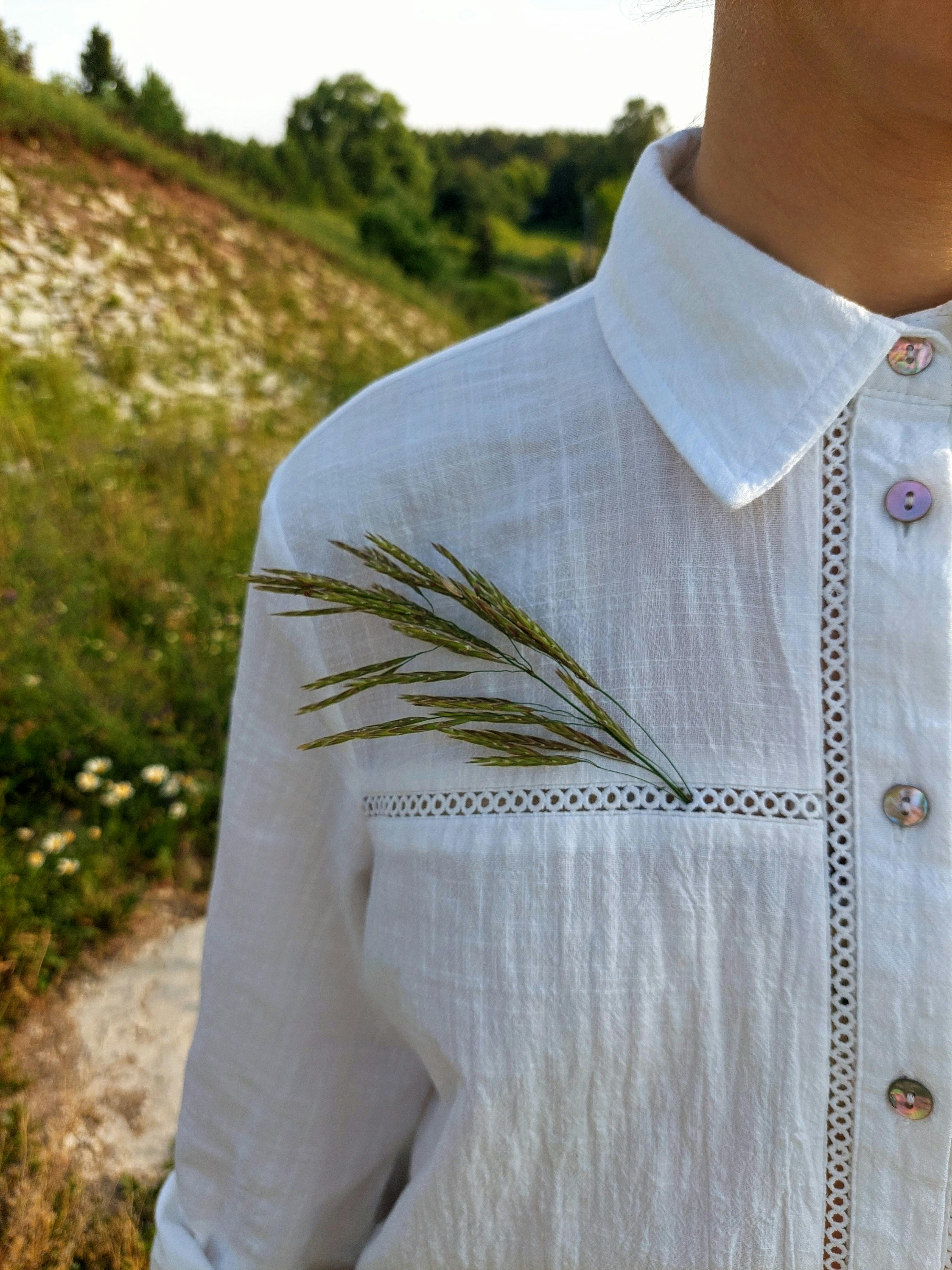 A woman wearing a white shirt with grass on it