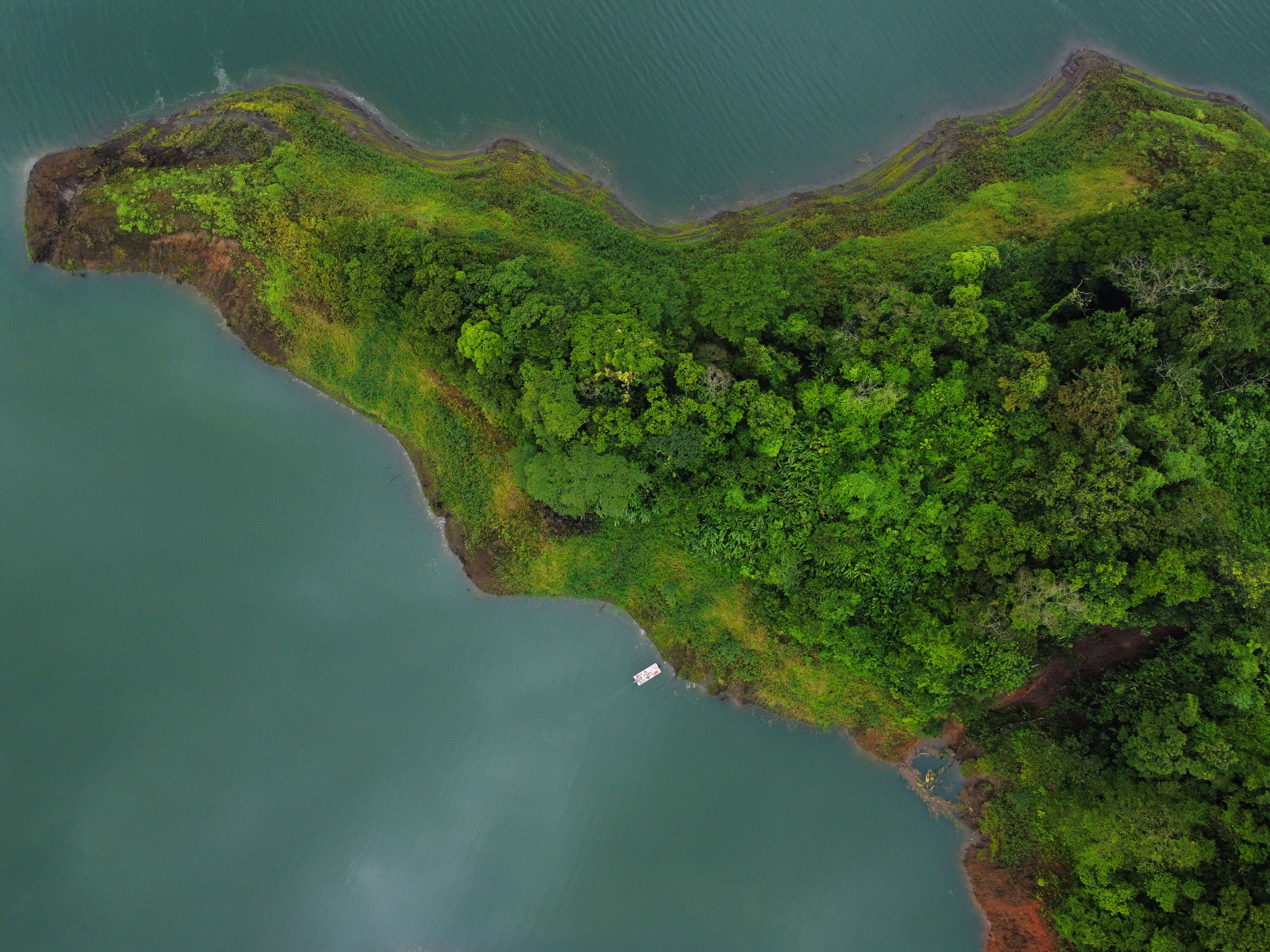 A stunning aerial shot of a green peninsula in La Fortuna, Costa Rica surrounded by blue waters. - La Fortuna