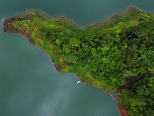 Free A stunning aerial shot of a green peninsula in La Fortuna, Costa Rica surrounded by blue waters. Stock Photo