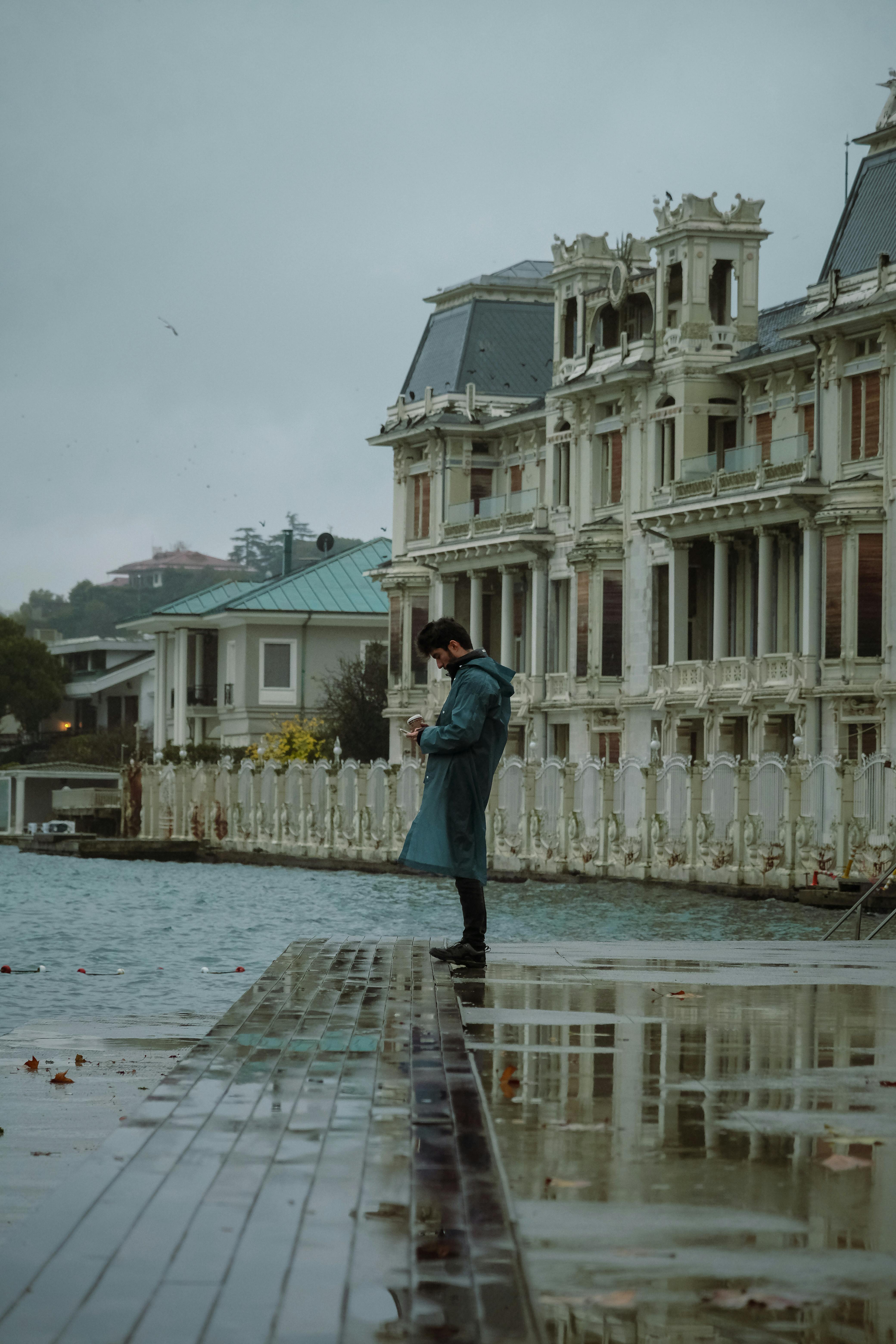 A moody scene of a man by the Bosphorus with historic buildings in Beykoz, İstanbul.