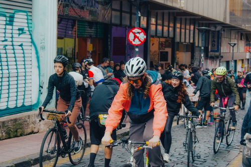 Free A vibrant group of cyclists in helmets ride through a bustling urban street. Stock Photo