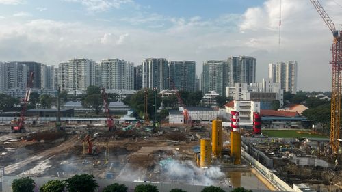 Free A bustling construction site set against a modern city skyline. Stock Photo