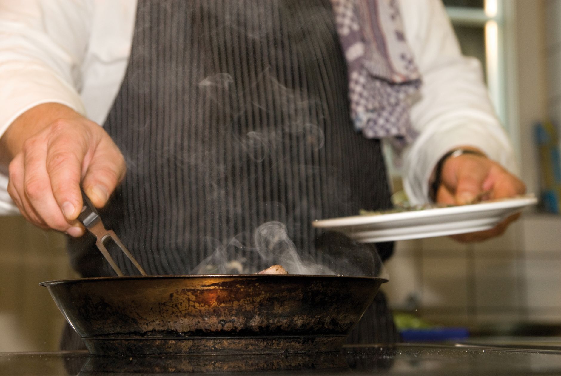 Preparación de Carne en Sartén Chef cocinando un trozo de carne en una sartén