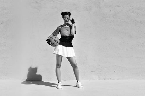 Free Stylish woman posing with basketball in a black and white urban setting. Stock Photo