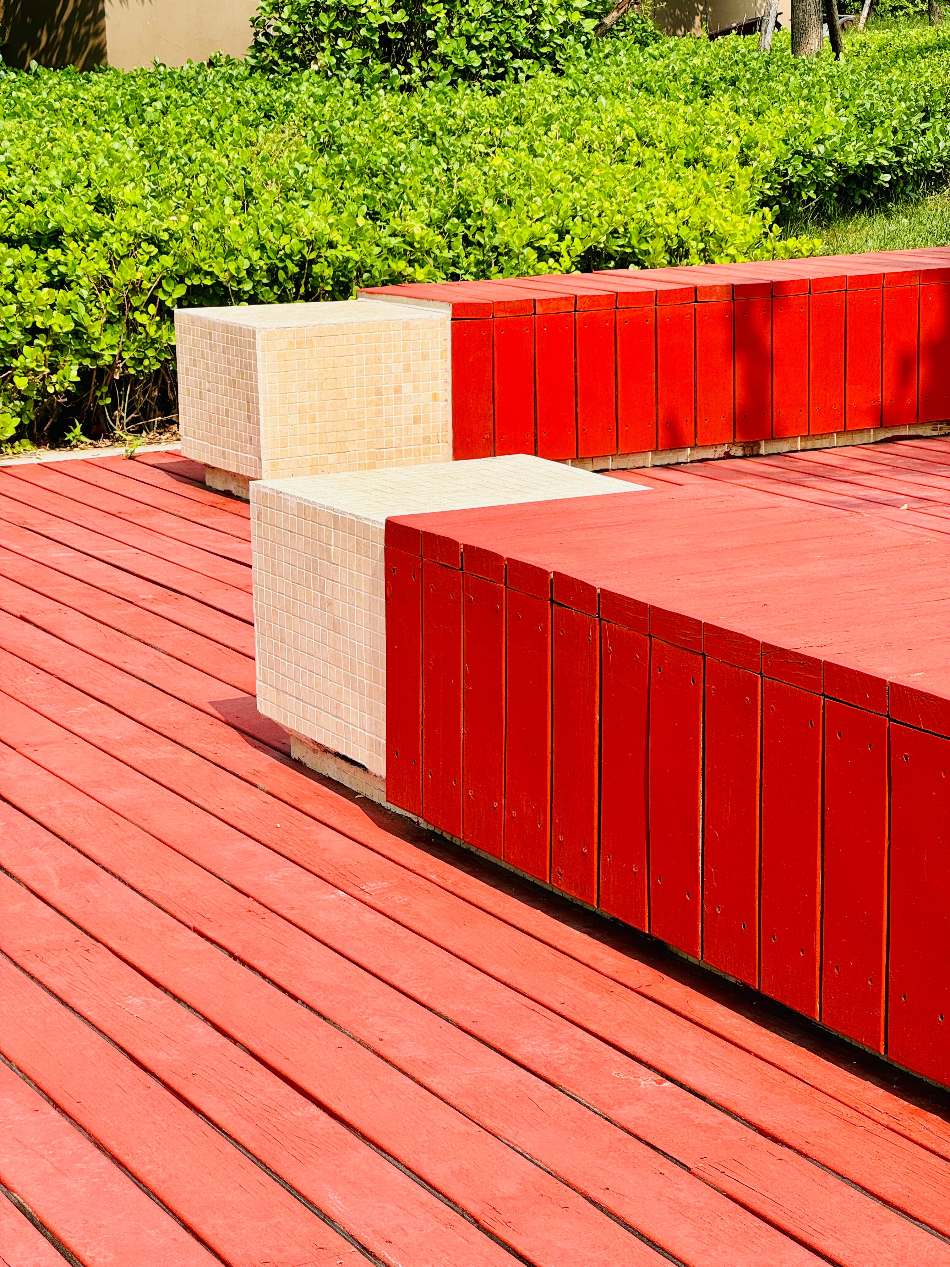 Vibrant red wooden bench in a lush green garden, Dongli District, Tianjin, China.