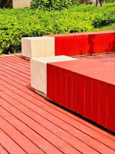 Vibrant red wooden bench in a lush green garden, Dongli District, Tianjin, China.