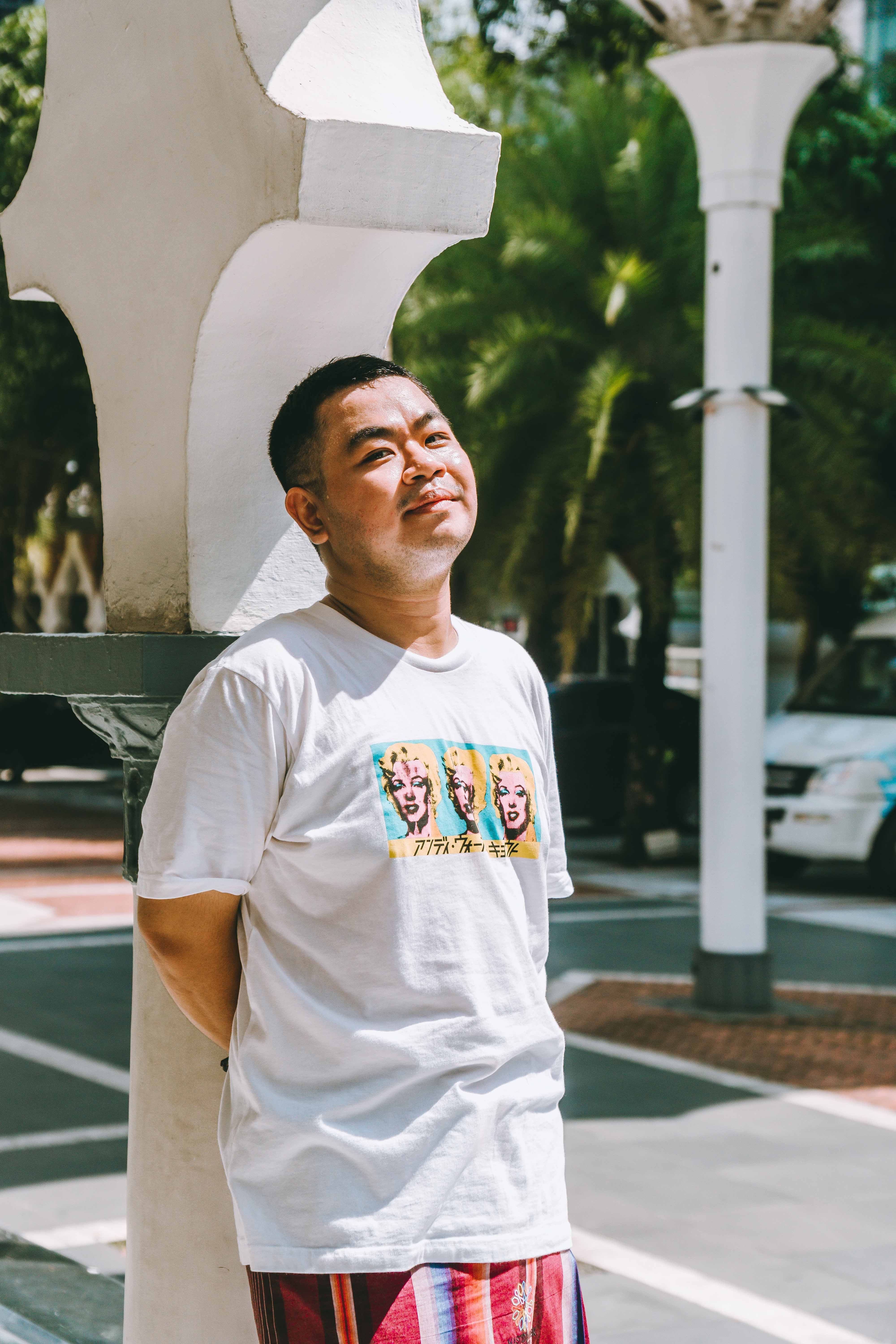 Relaxed portrait of a man enjoying the sunny streets of Kuala Lumpur.