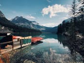 加拿大不列颠哥伦比亚省群山环绕的宁静湖泊上，独木舟构成一幅美景