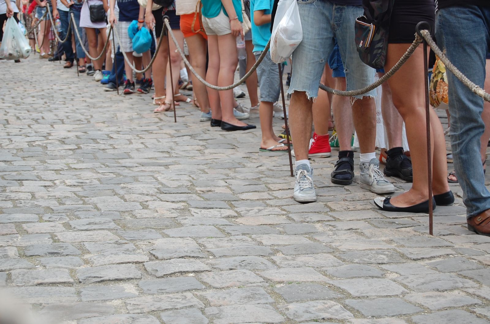 A crowd of people's feet standing close together in a line.