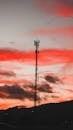 电信塔的轮廓在鲜艳的红色日落天空映衬下显得格外戏剧性