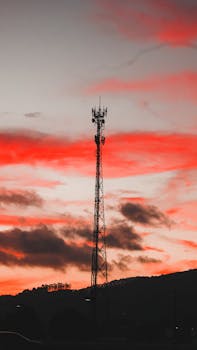 电信塔的轮廓在鲜艳的红色日落天空映衬下显得格外戏剧性