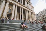 阳光明媚的日子里，人们在宏伟的地标建筑台阶上放松身心