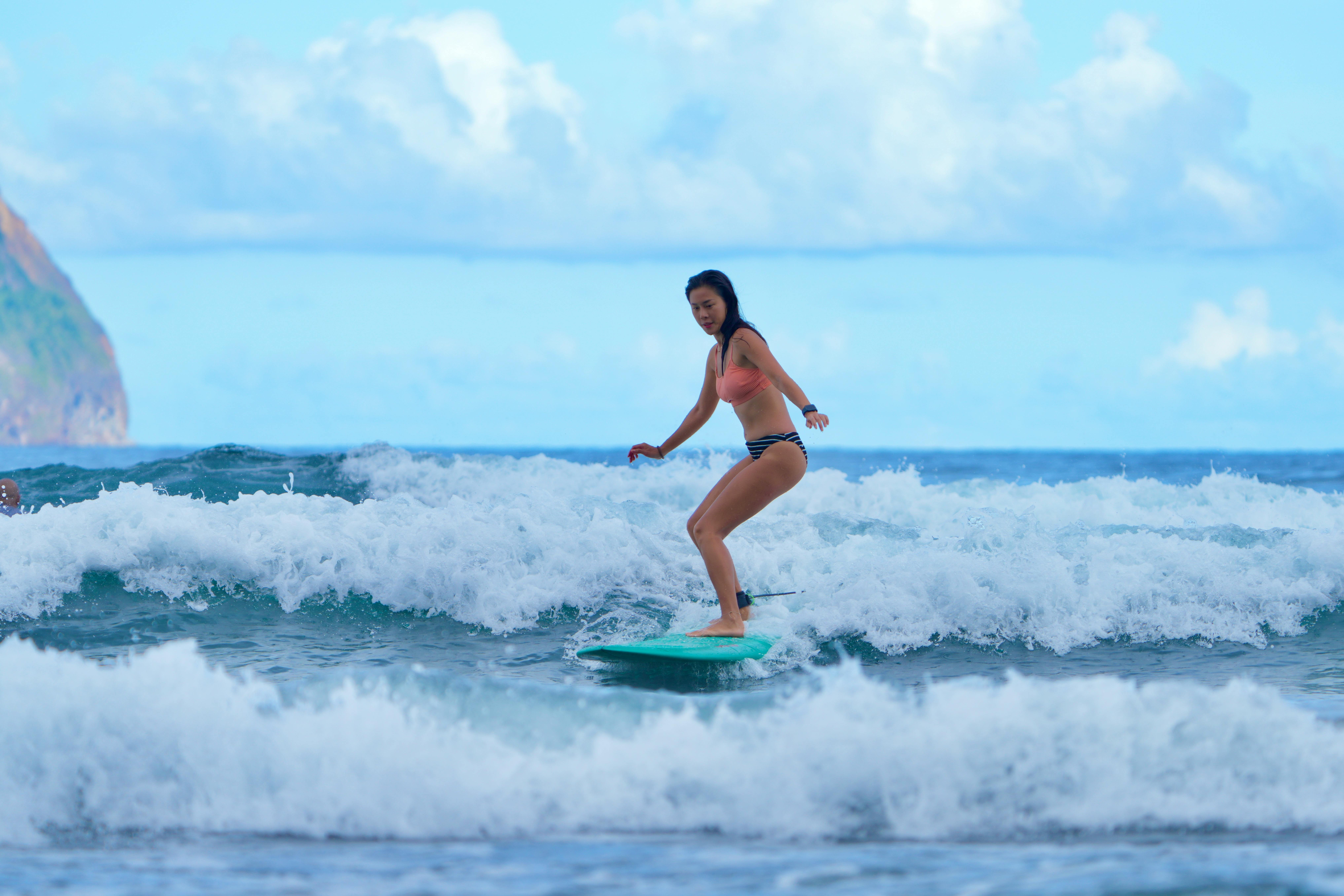 A young woman skillfully surfing on a vibrant beach, capturing the essence of summer fun and ocean adventure.