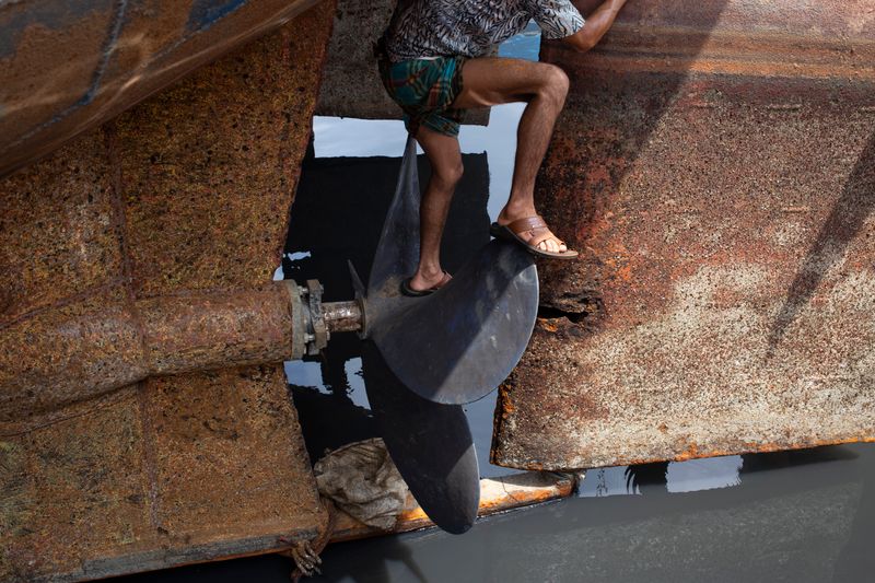 Engineer standing on the blades of a large ship propeller