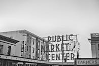 一张黑白照片，拍摄了公共市场标志及其周围的建筑