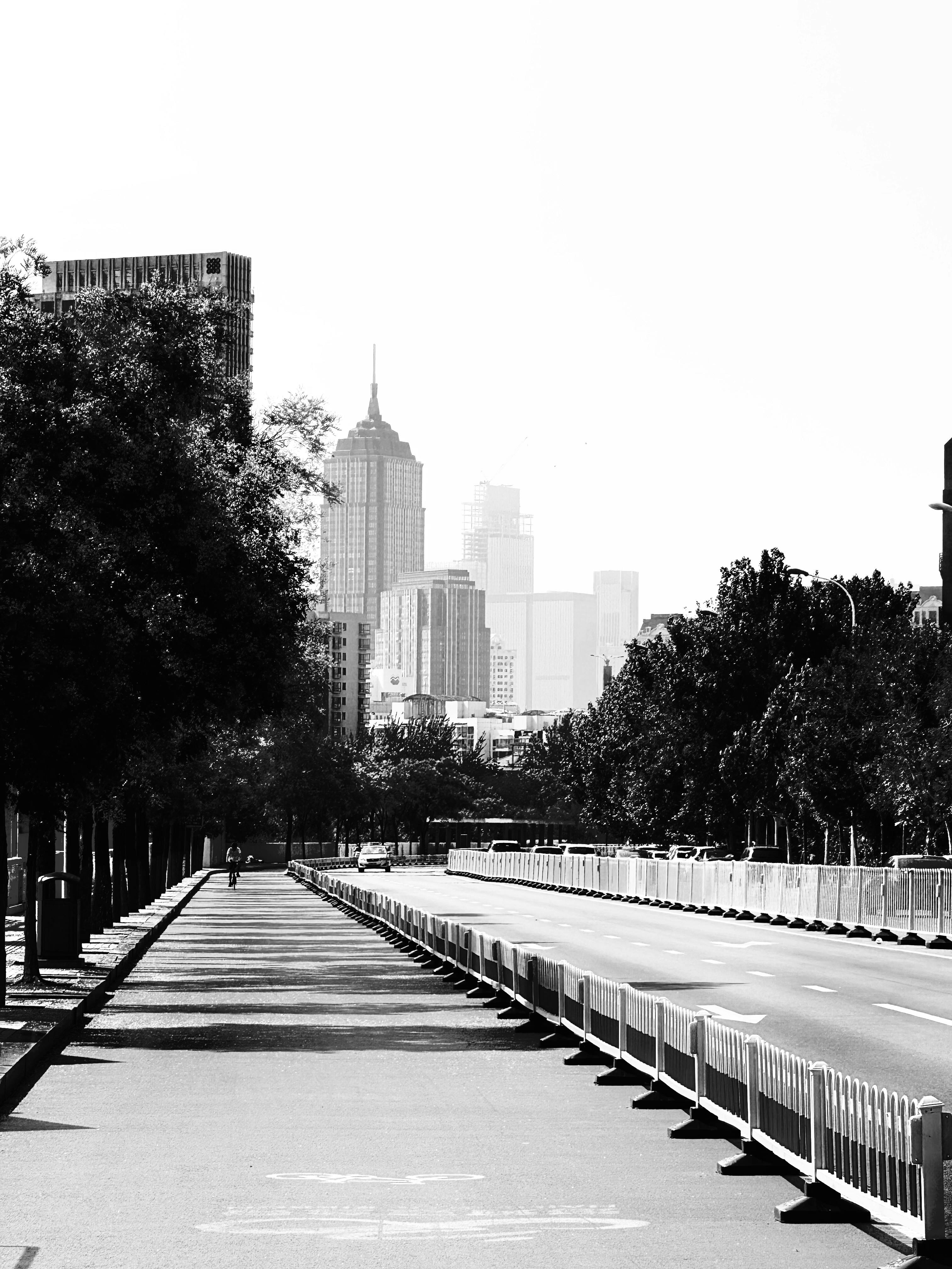 Monochrome view of a city street in He Xi, Tianjin, China, capturing urban life and skyscrapers.